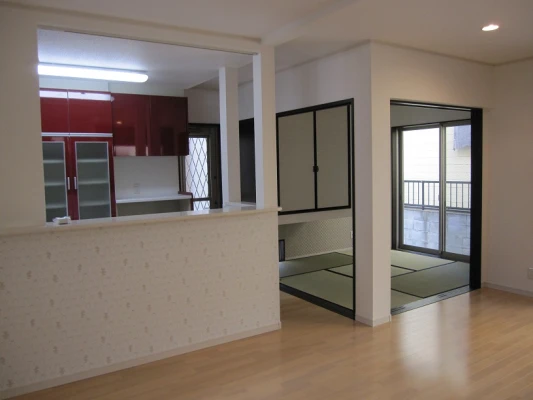 レッド色キッチンと隣接の畳スペース