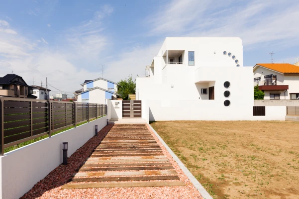 個性的な丸窓が並ぶホワイト色の外観