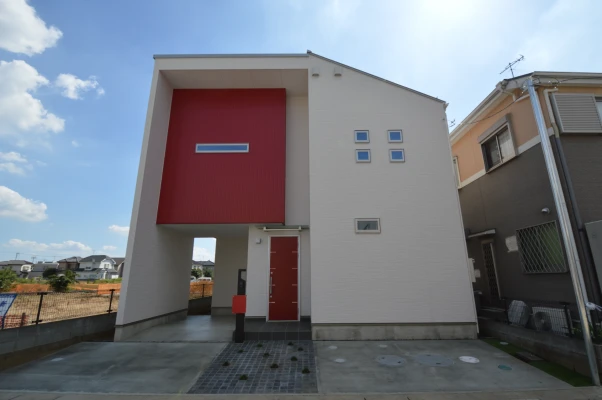 真紅に染まるピロティガレージのある外観