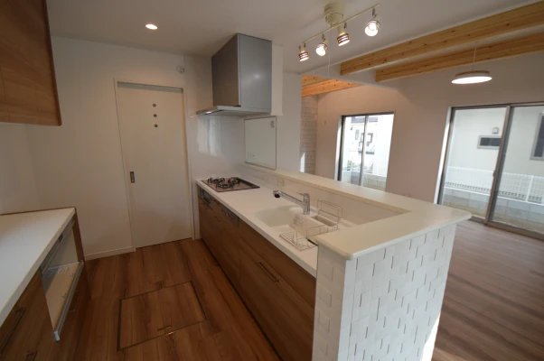 フロア一体色のキッチンと奥側パントリー