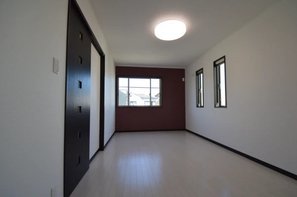 赤茶壁紙がアクセントの広々主寝室