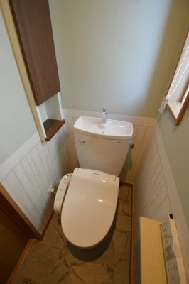 上部キャビネットと腰壁クロスの一階トイレ