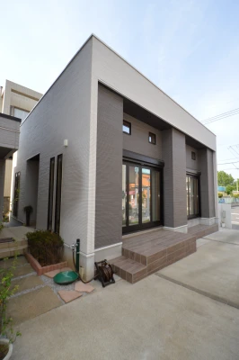 木目柄タイルデッキと電動シャッターの外観