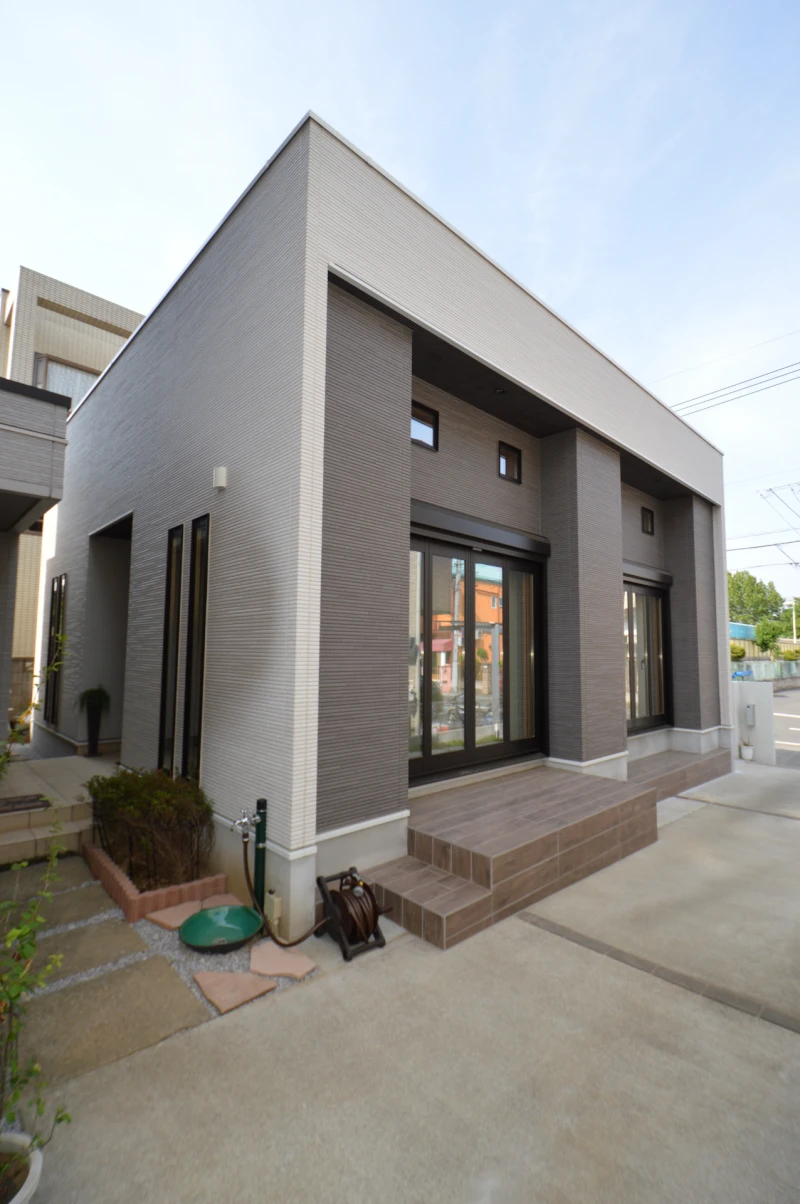 木目柄タイルデッキと電動シャッターの外観