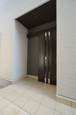 電子錠の玄関ドアと母屋へ繋がるポーチ