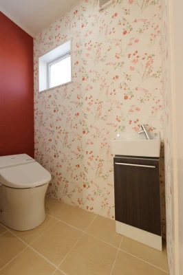 赤アクセントと花柄ベースの二階トイレ