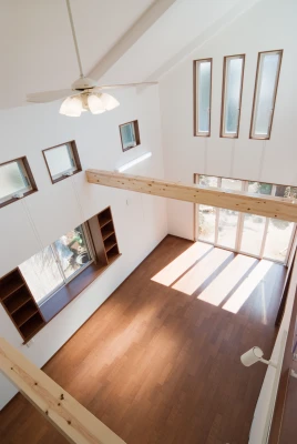 二階通路から見下ろす見せ梁のリビング