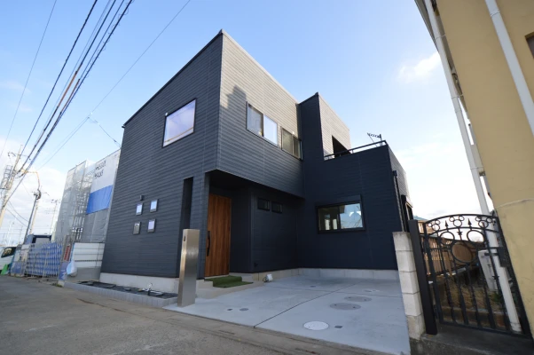 四窓がポイントの黒とステンカラーの外観