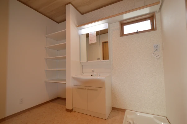 ハンガー付き棚のある３帖間の洗面脱衣室